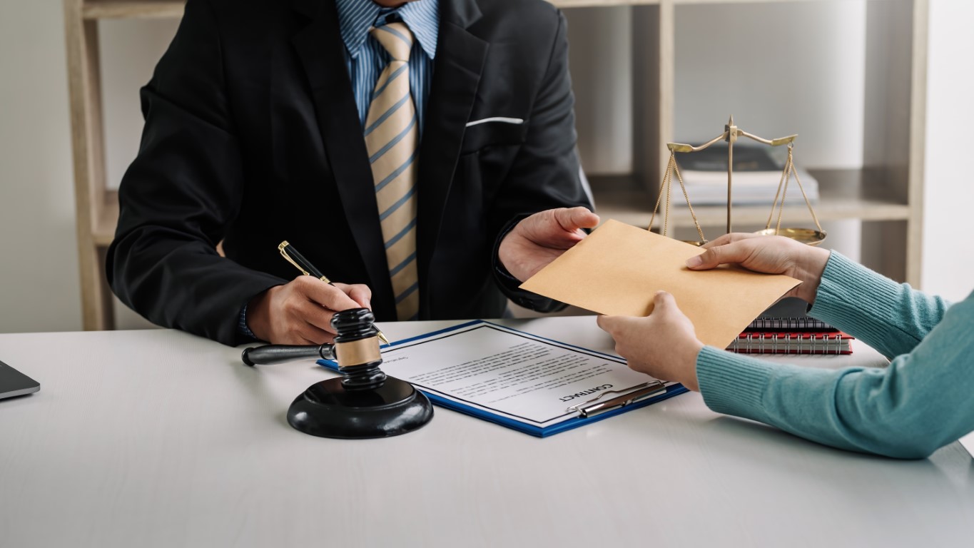 A lawyer receiving a document from their client in an office